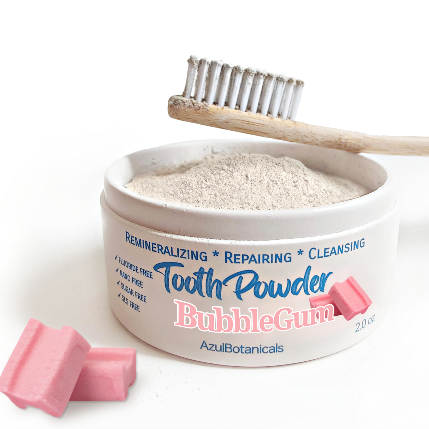 Container of AzuiBotanicals Bubble Gum tooth powder with a toothbrush and pink chewable tablets on a white background