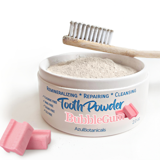 Container of AzuiBotanicals Bubble Gum tooth powder with a toothbrush and pink chewable tablets on a white background
